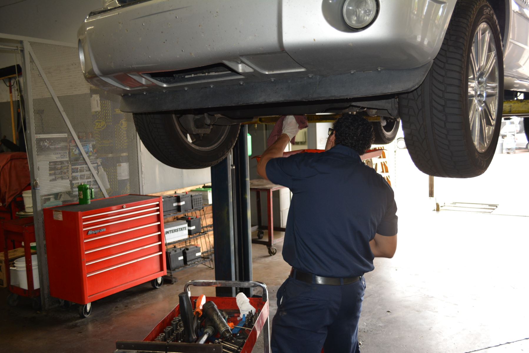 man working under elevated car